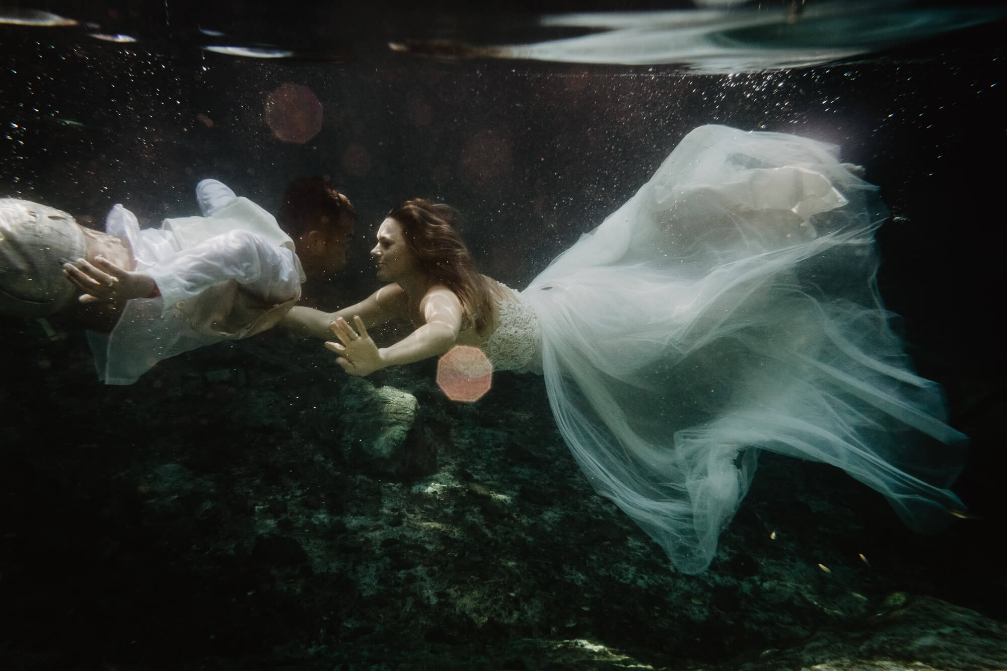 An underwater wedding photograph of a couple at aMEXICO FINEART DESTINATIONWEDDING AT PLAYA DEL CARMEN